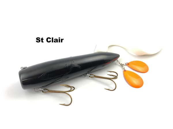 A St. Clair brand fishing lure with a glossy black body, two gold treble hooks, and two orange teardrop blades on a white background.